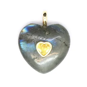 Gros plan détaillé d'un pendentif en labradorite en forme de cœur avec incrustation.