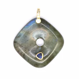 Close-up of square labradorite pendant with blue gemstone inlay and gold bail detail.