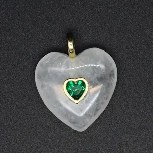 Pendentif cœur en cristal blanc exquis avec zircon vert dans un serti doré, vue détaillée.