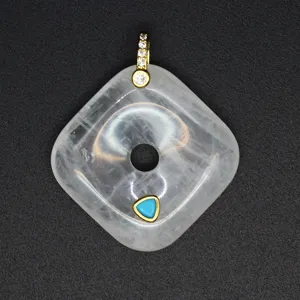 Detail view of the square crystal pendant with gold bail and turquoise inlay. Elegant jewelry.