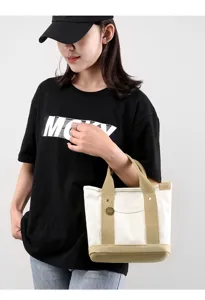 Detailed view of casual canvas tote bag with sturdy handles and reinforced neutral base.