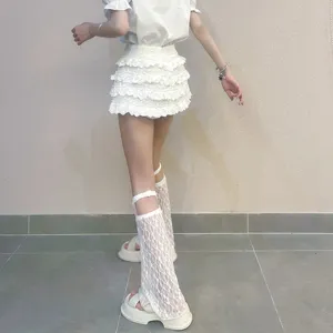 Detailansicht von weißen Spitzen-Beinstulpen und Volant-Minirock, japanischer Subkultur-Stil.