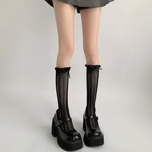 Japanische Lolita Spitzen-Wadenstrümpfe Detail kombiniert mit schwarzen Plateau Mary Jane Schuhen.