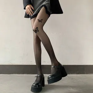 Close-up detail of sheer black tights featuring cute butterfly prints, paired with platform shoes.