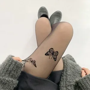 Close-up detail of black sheer pantyhose featuring elegant butterfly prints, stylish design.