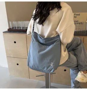 Λεπτομερής άποψη της casual γαλάζιας νάιλον τσάντας χιαστί με υφή και μπροστινή τσέπη.