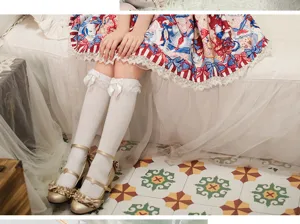 Lolita weiße Kniestrümpfe Detailaufnahme mit süßer Schleife und passenden Modeschuhen.