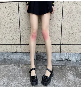 Close-up view of ultra-thin gradient blush pantyhose showing detailed knee effect and soft texture.