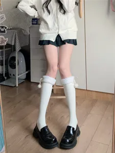 Japanese style white knee high socks with fluffy faux fur cuffs and cute pom pom details for winter.