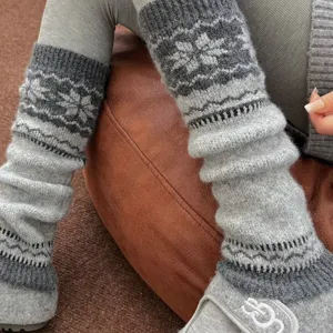 Grijs wollen beenwarmers voor vrouwen, gezellige winter sokken met klassiek Noords sneeuwvlok patroon.