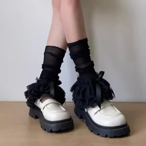 Nahaufnahme von schwarzen einlagigen Spitzen-Sockenstutzen mit Schleifen im süßen Lolita-Stil.