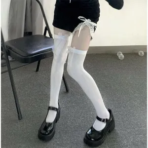 White over-the-knee stockings detail view featuring delicate white lace bow accents.