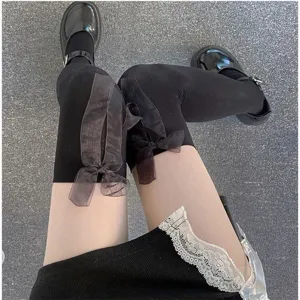 Black over-the-knee Lolita socks with sheer bow detail, worn with skirt for daily style.