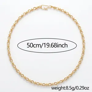 Dettaglio collana catena dorata, design minimalista con maglie intrecciate, gioiello.