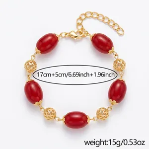Bracciale placcato oro con perle rosse imitate e sfere cave, accessorio regalo ideale.