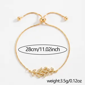 Dettaglio bracciale scorrevole in zircone foglia dorata, elegante gioiello da polso regolabile.
