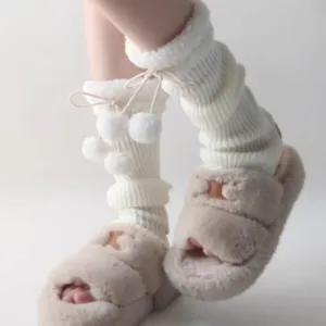 Cozy winter knitted leg warmers with cute plush pom poms and stylish drawstring design for women.