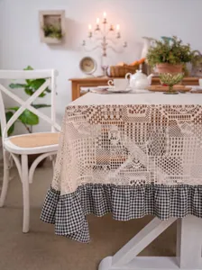 Elegant crochet lace tablecloth with rustic gingham ruffle for dining room decor.