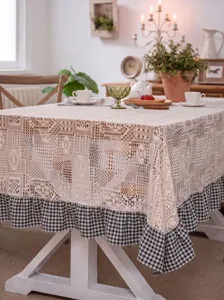 Detailed view of pastoral crochet lace tablecloth featuring black and white gingham ruffle