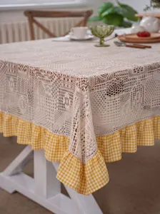 Detailed view of pastoral beige crochet lace tablecloth featuring yellow white plaid ruffle border.