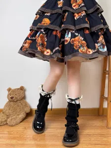 Detail shot of Japanese Lolita black knit leg warmers with white lace trim and cute bows.