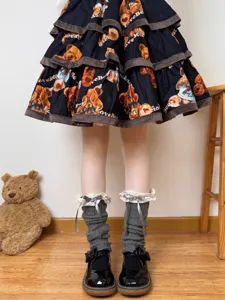 Detailed view of grey knitted leg warmers featuring delicate lace trim and cute grey bow knots.