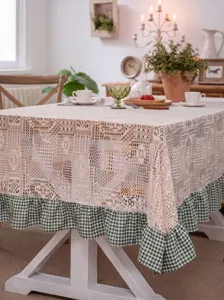 Rustic crochet lace tablecloth with green checkered ruffle hem for dining table decor.