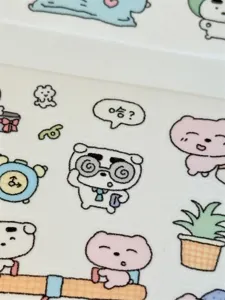 Close-up detail of cute cartoon puppy and bear PET sticker roll for journal decoration.