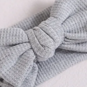 Bandeau bebe en maille gaufree grise avec grand noeud, accessoire cheveux doux pour nourrisson.