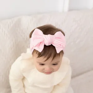 Bandeau en tricot gaufré pour bébé avec grand nœud, accessoire rose mignon pour les filles.