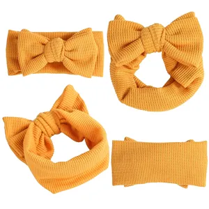 Vue détaillée du bandeau bébé en tricot gaufré jaune moutarde avec grand nœud pour le quotidien.