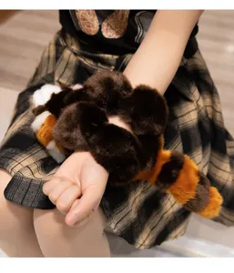 Detalle de pulsera de felpa con cola esponjosa usada suavemente en la muñeca.