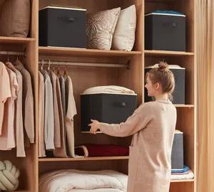 Boîte de rangement noire en tissu non tissé pour placard avec des poignées solides.