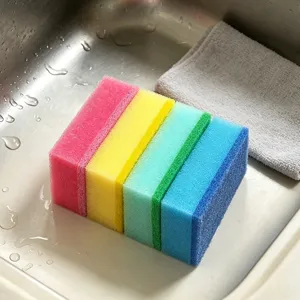 Vue détaillée d'un ensemble d'éponges de nettoyage double face colorées dans un évier de cuisine.