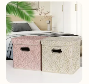 Detail view of foldable fabric storage boxes with floral pattern and metal handles.