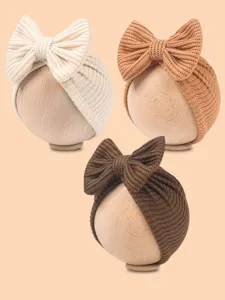Newborn knit bow baby turban hat detail shot, soft winter beanie in three colors.