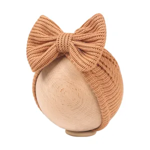 Detailed close-up of newborn knit bow beanie baby turban hat in khaki color soft texture.