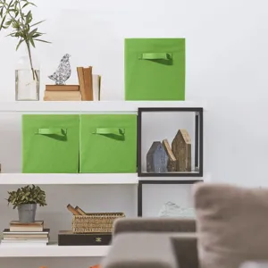 Detail view of green foldable storage box on white shelf for home wardrobe organization.