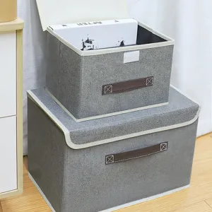 Scatola di immagazzinaggio pieghevole in tessuto grigio con coperchio e maniglie per vestiti.
