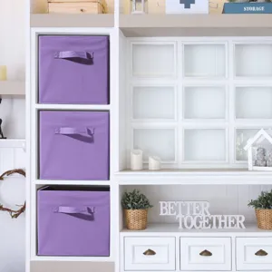 Detailed view of purple foldable storage box placed neatly in white wooden shelf unit.