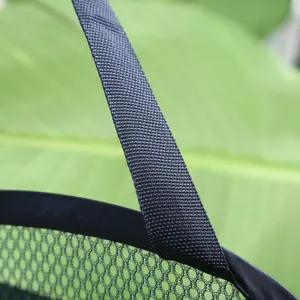 Gedetailleerde close-up van de duurzame zwarte geweven band en ademende groene wasmand van mesh.
