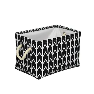 Panier de rangement en tissu géométrique noir et blanc avec poignées en corde pour jouets.