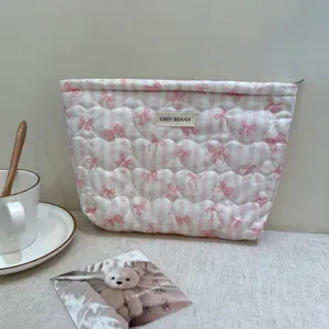 Quilted cosmetic bag with pink white stripes, cute heart bow pattern, and convenient zipper closure.
