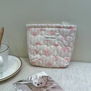 Pink striped quilted makeup pouch with heart pattern, cute aesthetic storage bag for daily use.