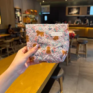 Detailed view of cute pink canvas cosmetic bag with puppy and floral print for daily use.