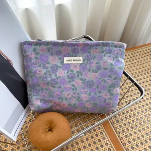 Borsa cosmetica in jacquard floreale viola e rosa, con etichetta tessuta e comoda cerniera.