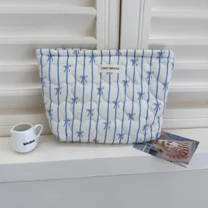 Blauw gestreepte gewatteerde make-up tas met strik, draagbare reistas voor dagelijks gebruik.