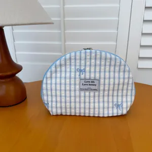 Blue plaid cosmetic bag with embroidered bows, portable makeup pouch and zipper storage.