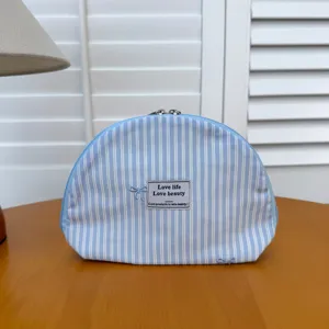 Blue striped cosmetic bag with bow embroidery fabric portable shell makeup pouch for travel.