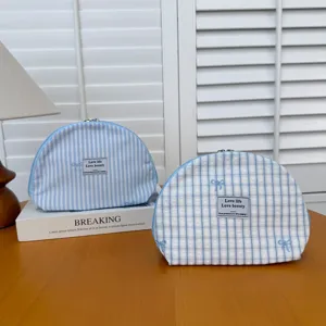 Blue striped and plaid cosmetic bag with bow embroidery, portable shell makeup pouch detail.